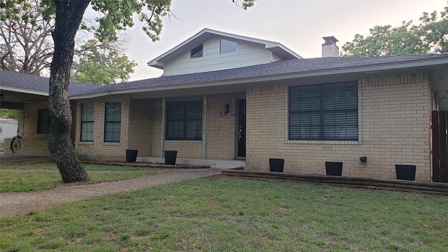703 San Jacinto St, Mineral Wells, TX 76067 - view of front of property with a front yard, brick siding, and a chimney