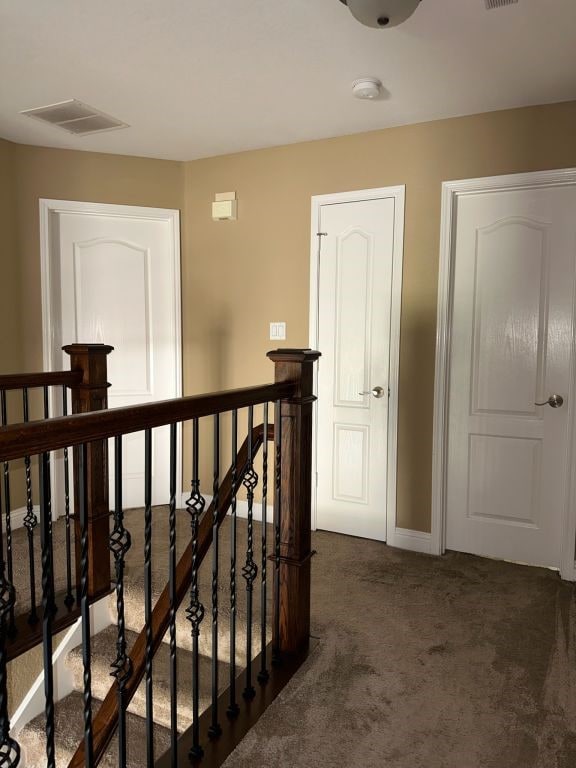 hallway featuring dark colored carpet