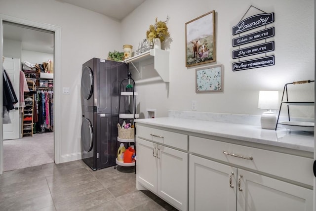 washroom with light carpet, cabinets, and stacked washing maching and dryer