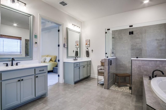 bathroom featuring tile patterned flooring, vanity, and separate shower and tub