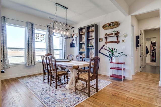 dining room with hardwood / wood-style floors and a notable chandelier