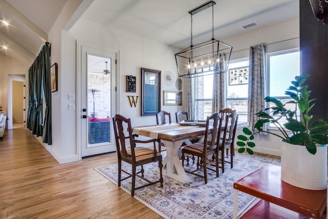 dining space featuring light hardwood / wood-style flooring and a chandelier