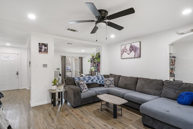 living room with ceiling fan and light hardwood / wood-style flooring