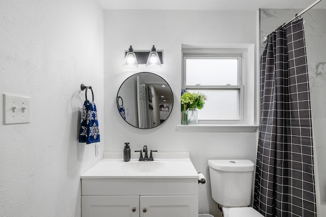 bathroom with vanity, toilet, and walk in shower