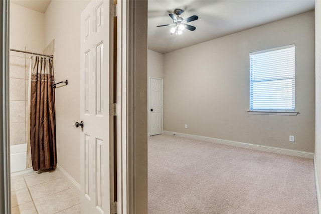 2605 Waterstone Ln, Rockwall, TX 75032 - unfurnished bedroom with baseboards, light carpet, a ceiling fan, and light tile patterned floors