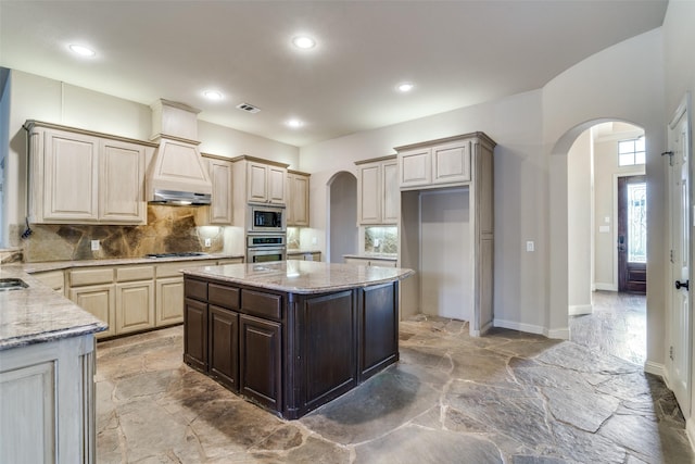 kitchen featuring arched walkways, appliances with stainless steel finishes, backsplash, and visible vents