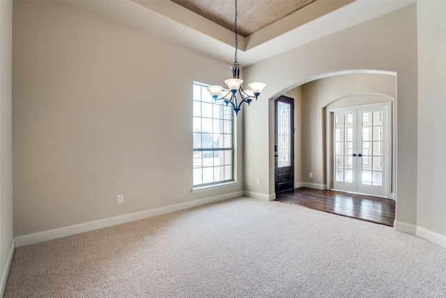 2605 Waterstone Ln, Rockwall, TX 75032 - unfurnished room with dark colored carpet, arched walkways, a chandelier, french doors, and baseboards