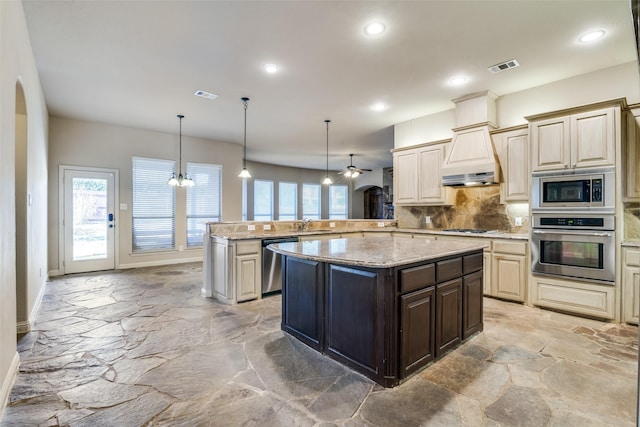 2605 Waterstone Ln, Rockwall, TX 75032 - kitchen with stainless steel appliances, light stone finish floors, backsplash, a ceiling fan, and baseboards