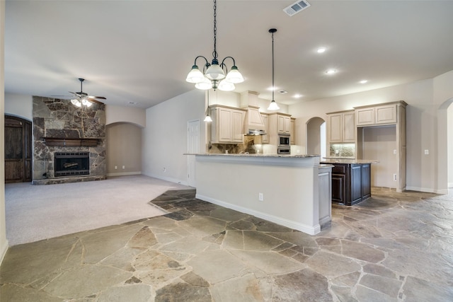 2605 Waterstone Ln, Rockwall, TX 75032 - kitchen featuring stone flooring, arched walkways, a ceiling fan, baseboards, and pendant lighting