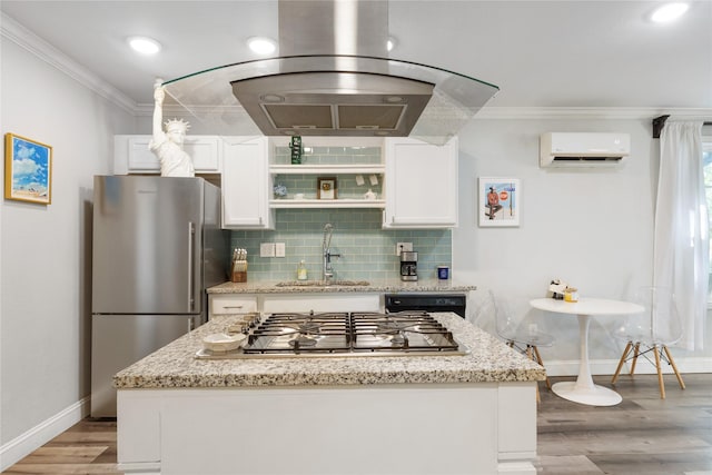 kitchen with sink, light stone counters, a wall mounted air conditioner, appliances with stainless steel finishes, and white cabinets