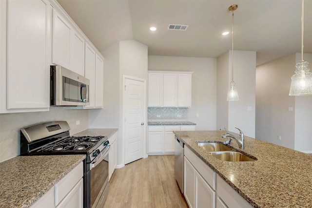 716 Tawny Turn, Lavon, TX 75166 - kitchen with visible vents, decorative backsplash, a sink, light wood finished floors, and appliances with stainless steel finishes