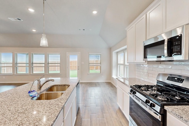 721 Merry Summit Rd, Lavon, TX 75166 - kitchen with appliances with stainless steel finishes, a sink, light wood-type flooring, lofted ceiling, and baseboards