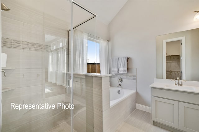 bathroom with tile patterned flooring, vanity, separate shower and tub, and lofted ceiling