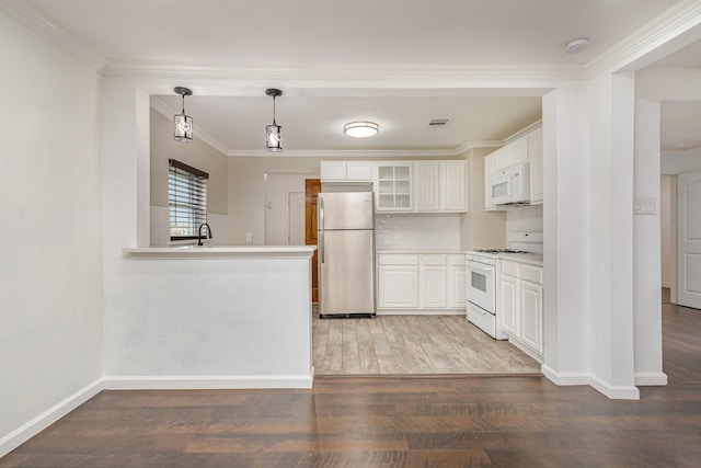 kitchen with pendant lighting, hardwood / wood-style floors, white cabinetry, kitchen peninsula, and white appliances