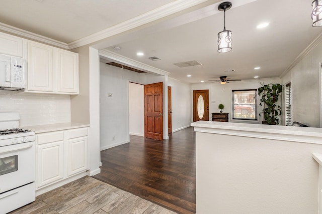 kitchen with tasteful backsplash, crown molding, white cabinets, and white appliances