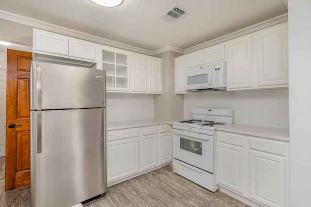 kitchen with crown molding, light wood-type flooring, white cabinets, white appliances, and backsplash