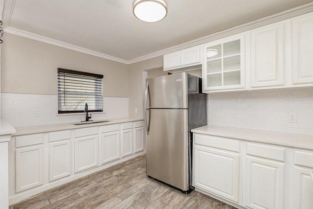 kitchen featuring white cabinetry, sink, and stainless steel refrigerator