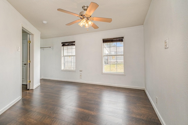 empty room featuring dark wood-type flooring, a textured ceiling, and ceiling fan