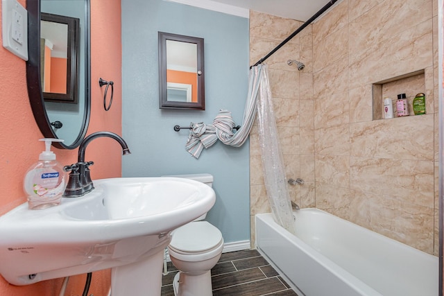 full bathroom featuring sink, shower / bathtub combination with curtain, and toilet