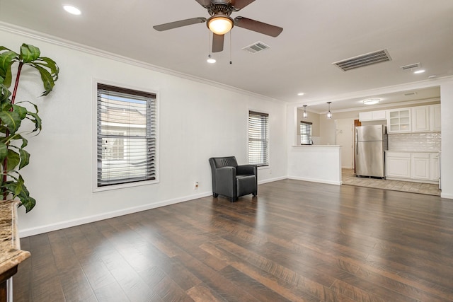 sitting room with crown molding, dark wood-type flooring, and ceiling fan