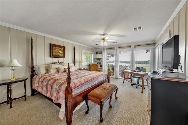 bedroom with ceiling fan, ornamental molding, light carpet, and a textured ceiling