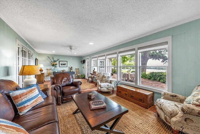 living room with ornamental molding, ceiling fan, and a textured ceiling