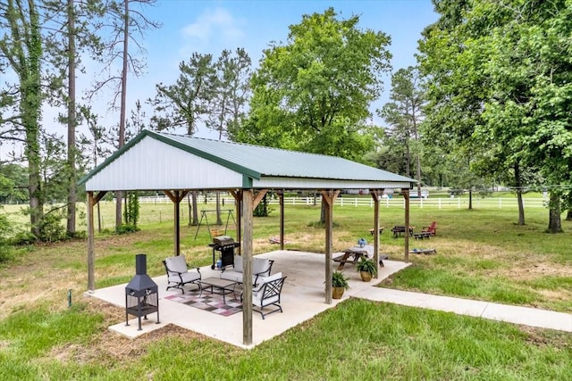 surrounding community with a gazebo, a patio area, a fire pit, and a lawn