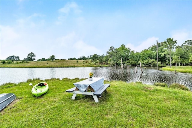 view of dock featuring a water view and a lawn