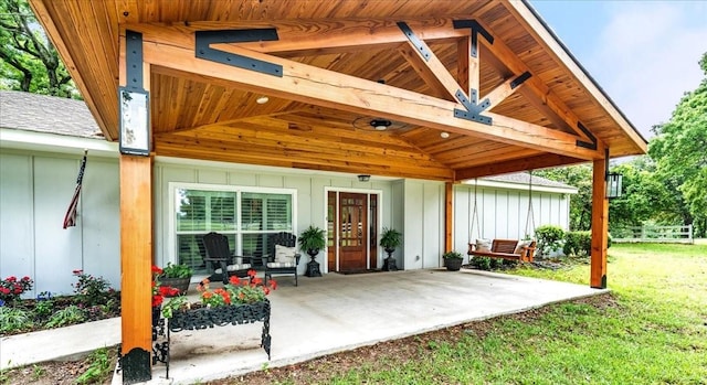 entrance to property featuring a yard and a patio area