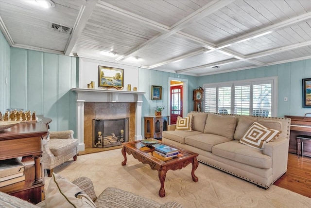 living room with beam ceiling, plenty of natural light, a premium fireplace, and light wood-type flooring