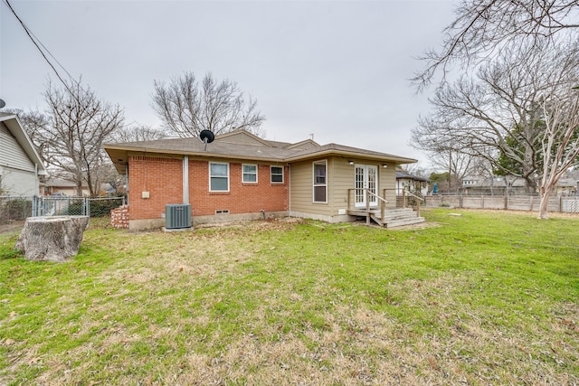 rear view of house with a yard and central AC