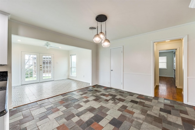 unfurnished dining area featuring crown molding, ceiling fan, and french doors