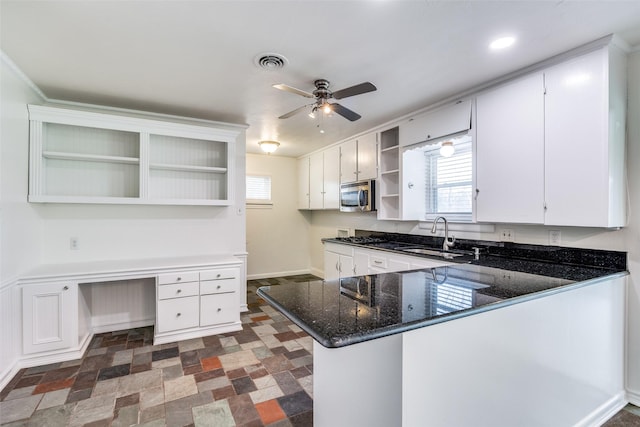 kitchen featuring white cabinets, kitchen peninsula, sink, and built in desk