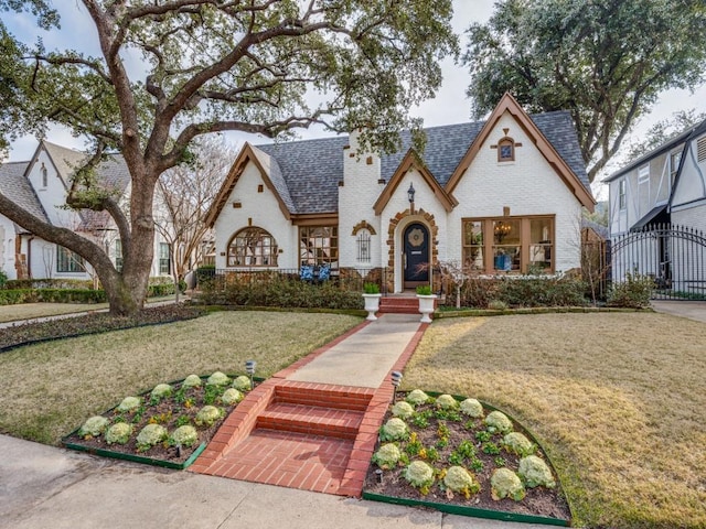 english style home with a front lawn