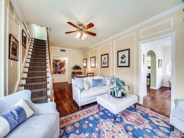 living room with crown molding, dark hardwood / wood-style floors, and ceiling fan