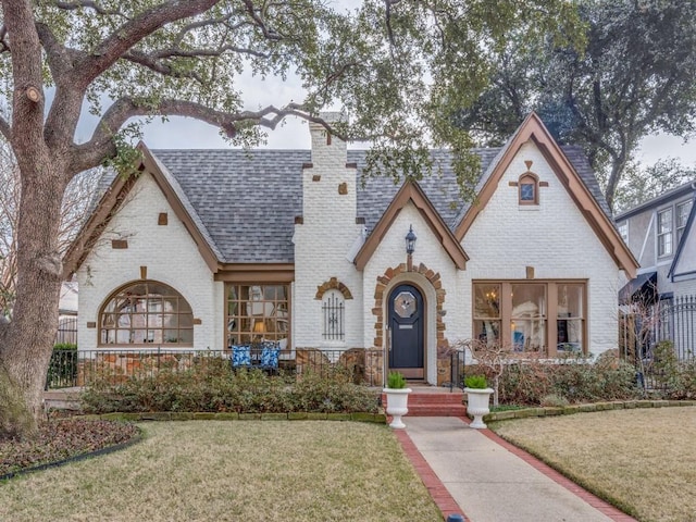 tudor-style house featuring a front yard