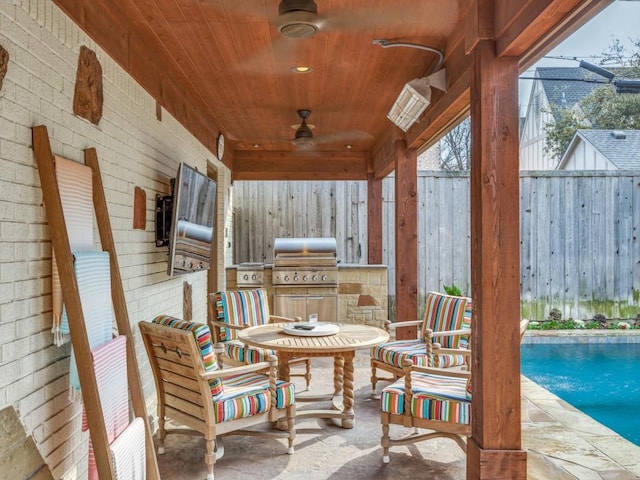 view of patio with exterior kitchen, a grill, and ceiling fan