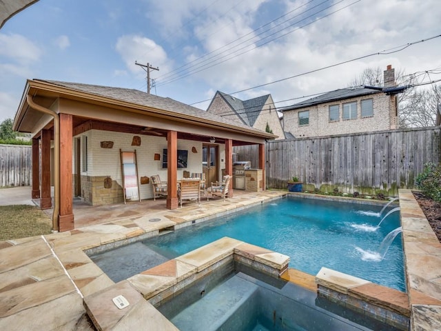 view of pool with an in ground hot tub, pool water feature, area for grilling, and a patio area