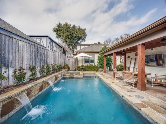 view of swimming pool with pool water feature, a jacuzzi, and a patio area