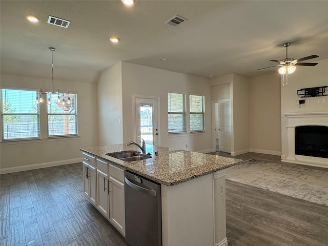 kitchen featuring sink, stainless steel dishwasher, white cabinets, light stone countertops, and a kitchen island with sink