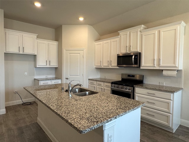 kitchen featuring an island with sink, stainless steel appliances, sink, white cabinets, and stone countertops