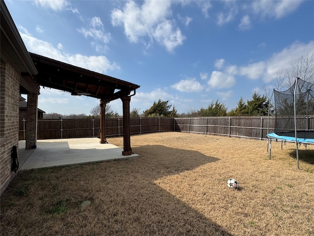 view of yard featuring a trampoline and a patio