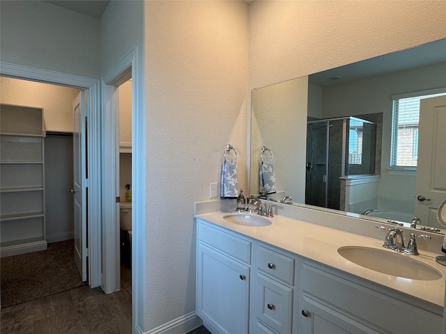 bathroom featuring plus walk in shower, vanity, and hardwood / wood-style floors