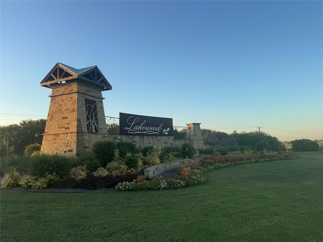 community sign featuring a yard