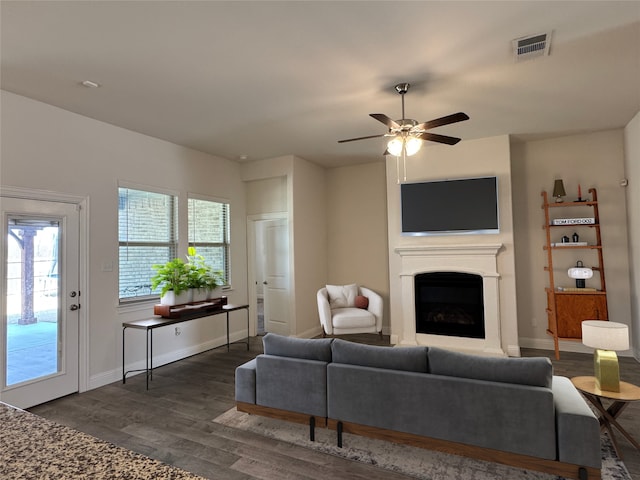 living room with ceiling fan, plenty of natural light, and dark hardwood / wood-style flooring