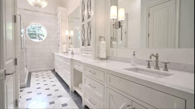 bathroom featuring tile patterned floors, a sink, a shower stall, and double vanity