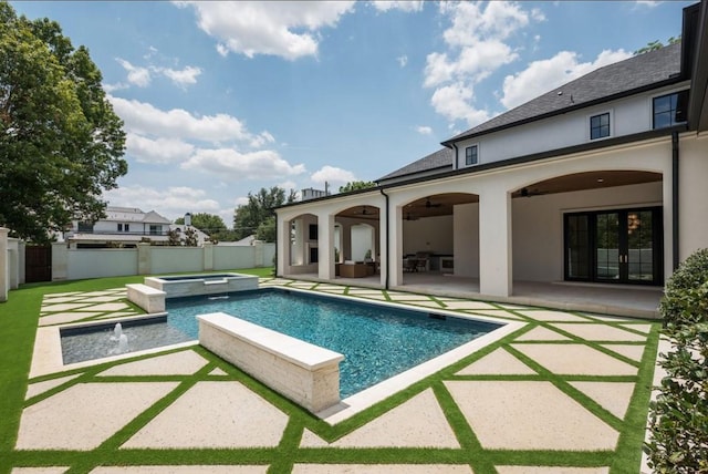 view of swimming pool with a ceiling fan, a pool with connected hot tub, a fenced backyard, and a patio