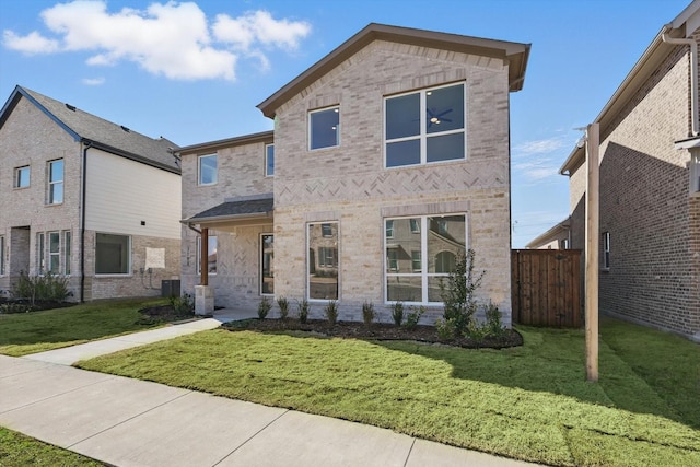 view of front of house featuring a front yard, fence, cooling unit, and brick siding