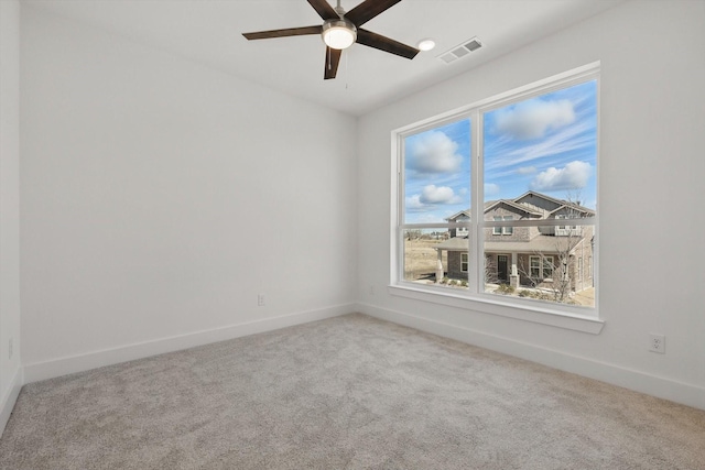 unfurnished room featuring baseboards, ceiling fan, visible vents, and light colored carpet