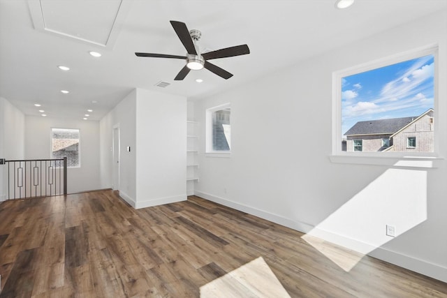 empty room with wood finished floors and recessed lighting